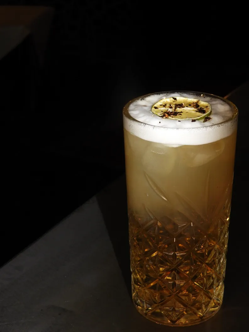 Der Diplomatico Rum Cocktail vereint den hochwertigen Diplomatico Rum mit einem selbstgemachten Honig-Vanillesirup, frischem Limettensaft und Ingwersaft, um ein intensives und einzigartiges Geschmackserlebnis zu schaffen. Verfeinert mit edlem Blattgold Golden Elegance, wird dieser Cocktail nicht nur geschmacklich, sondern auch optisch zu einer wahren Kreation. Die perfekte Mischung aus hochwertigem Rum und handgefertigten Zutaten macht diesen Drink zu einem exklusiven Erlebnis. Exklusive Cocktails in Winterthur erreichen mit diesem Cocktail eine neue Dimension – ideal für anspruchsvolle Geniesser, die das Besondere suchen.